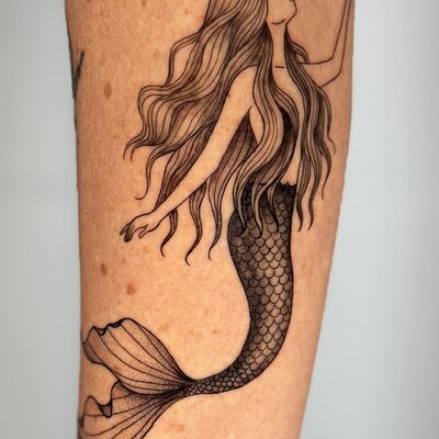 Fine line mermaid tattoo with flowing hair and detailed scales by Reni Tattoo Gold Coast